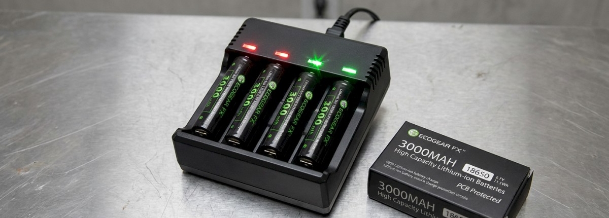 18650 batteries in charger with charger LED lights on and items on steal table