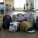 Array of gym backpacks in various styles, displayed on a gym floor with equipment in the background