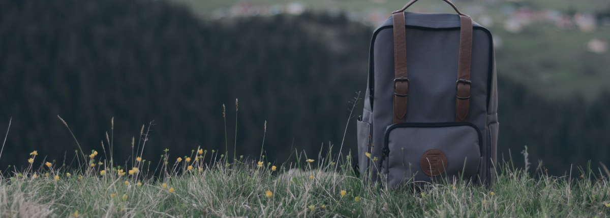 backpack on grass field in sunshine