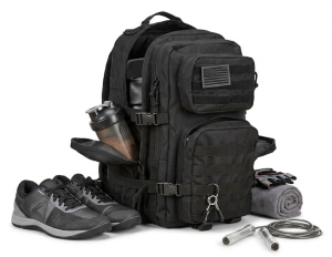 backpack used as a gym bag on a floor with shoes and a towel