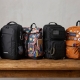 A diverse lineup of backpacks on a wooden table, each representing a different lifestyle and personality