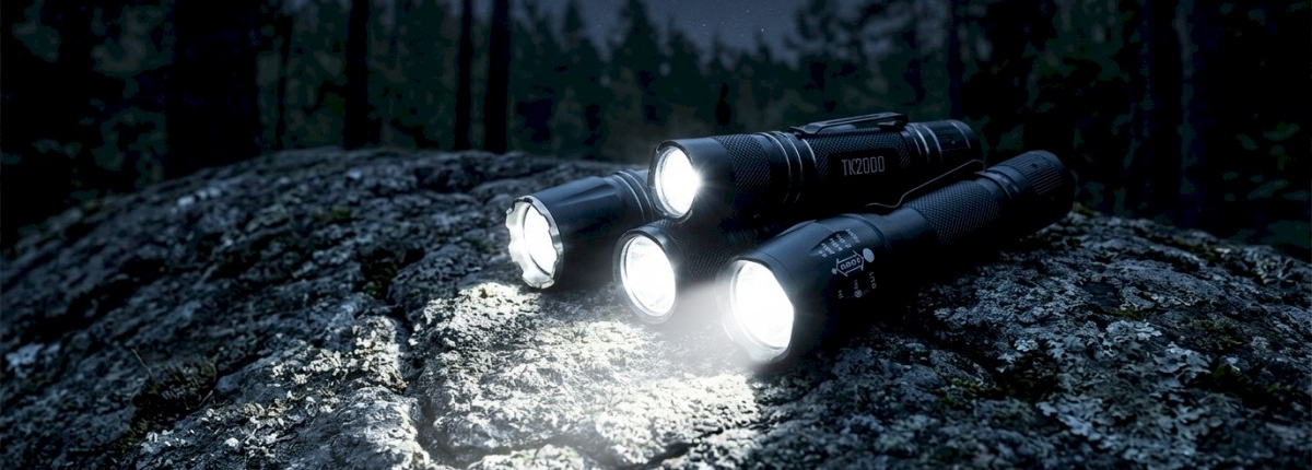 group of flashlights with lights on sitting on a large rock, forest night sky