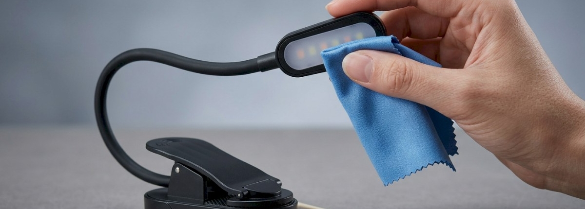 Book light on table showing maintenance by cleaning the LED lens with a cloth