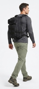 man wearing a backpack while walking on a trail