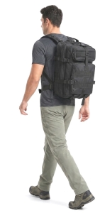 man wearing large tactical backpack while walking on an urban street