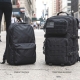 Side‑by‑side comparison of a compact daypack and a larger traditional backpack on a city sidewalk