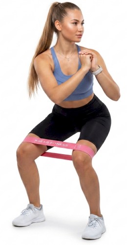 woman using loop resistance bands doing russian twist on white background