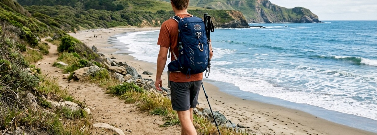 young man on a beach hiking trail with small ocean waves crashing